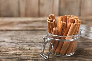 Cinnamon sticks on a textured wooden background. Cinnamon roll. Spicy spice for baking, desserts and drinks. Fragrant ground cinnamon. cinnamon powder Close-up. Place for text. copy space