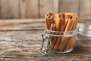 Cinnamon sticks on a textured wooden background. Cinnamon roll. Spicy spice for baking, desserts and drinks. Fragrant ground cinnamon. cinnamon powder Close-up. Place for text. copy space