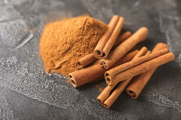 Cinnamon sticks on a textured wooden background. Cinnamon roll. Spicy spice for baking, desserts...