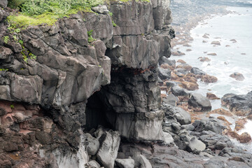 View of the cave in the cliff at the seaside