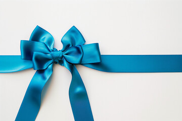 A satin blue bow tied on a ribbon against a white background.