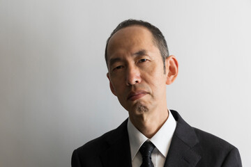 睨むスーツ姿の日本人の中年男性のポートレイト
