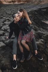 beautiful and young lovers, a guy and a girl are walking on an unusual terrain similar to the moon. Happy couple of European appearance on a first date in nature, smiling and relaxing