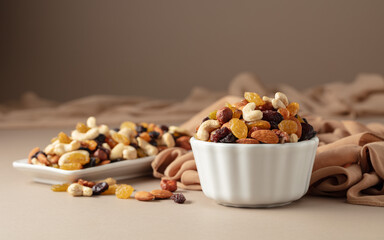 The mix of various nuts and raisins on a beige background.