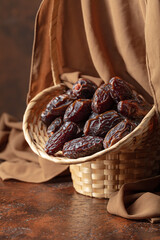 Dates in a old basket on a brown background.