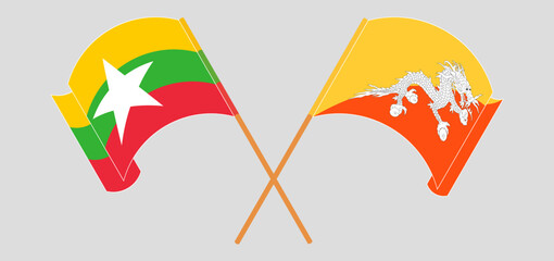 Crossed and waving flags of Myanmar and Bhutan