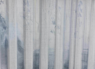 The surface texture of a dirty white painted metal fence