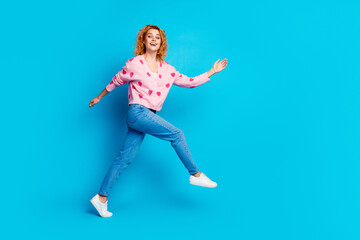 Fototapeta na wymiar Full length photo of lovely young lady running have fun dressed stylish pink clothes isolated on blue color background