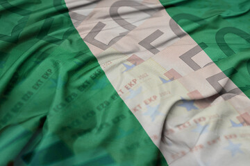 waving colorful national flag of nigeria on a euro money banknotes background. finance concept.