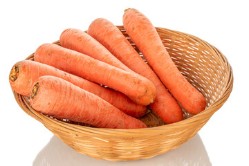 A few sweet carrots in a straw bowl, macro, isolated on a white background.