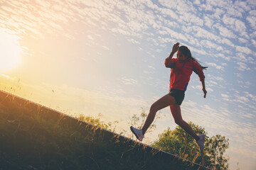 Silhouette of young woman running sprinting on road. Fit runner fitness runner during outdoor...