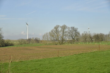 Éoliennes se dressant haut dans le ciel derrière les champs à Ghislenghien (Ath)
