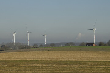Groupe d'éoliennes sous une chape de pollution en zone rurale à Ghislenghien 