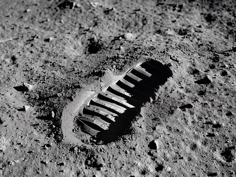 Gros-plan sur l'empreinte de la botte d'un astronaute dans le sol poussiéreux de la Lune.