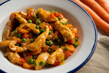 Chicken strips sautéed with peppers, peas, onion and carrot.