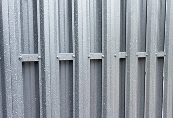 Modern metal and steel fence with water drops around the house. Design and architecture of a modern house.