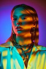 Elegance of classic style with modern jewelry combination. Beautiful young girl posing against gradient background in neon light. Concept of modern fashion, trendy style, beauty, youth culture