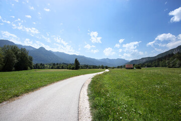 Fototapeta na wymiar vista con inquadratura panoramica su un bellissimo ambiente naturale di montagna in Slovenia, con un'ampia vallata e delle basse montagne, di giorno, in estate, sotto un cielo sereno