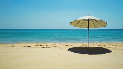 beach umbrella casting a shadow over a sandy beach, creating a tranquil spot to escape the blazing summer sun.