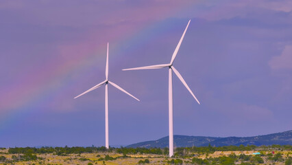 AERIAL: Wind farm stands tall against sky showcasing renewable energy technology