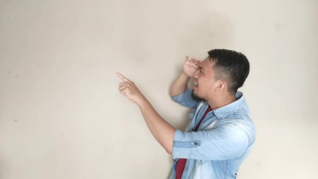 Asian mature man pointing to the right side while looking for something