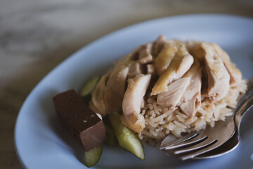 Steamed chicken with rice served with cucumber in a blue dish. Selective focus