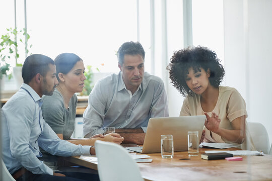 Team, business people and discussion on laptop in office for planning or brainstorming ideas in startup. Collaboration, creative or staff in meeting on computer for strategy or editor in conversation - Powered by Adobe