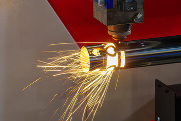 Close up scene the fiber laser cutting machine cut the stainless steel tube and sparkling light.