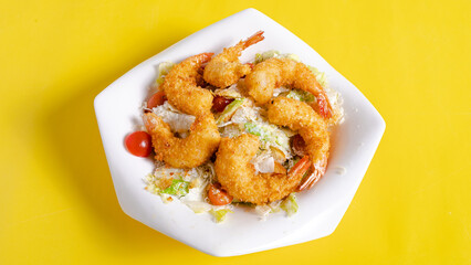 Caesar prawns salad bowl isolated on yellow 