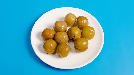 Pickled plum on plate isolated on blue