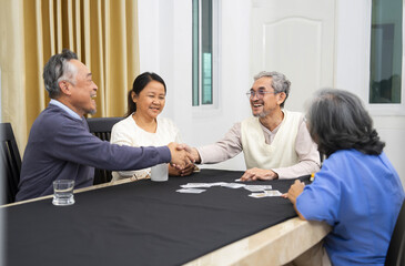 group of active senior friends meet and play cards game together,concept elderly retired people entertainment,recreation,encourages social interaction,help memory retention