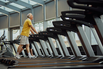 Cardio training to fat burning. Cheerful older adults, man and woman, make gym time enjoyable with...