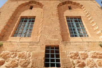 Three windows on the facade of a traditional house in the old town of Mardin, decorated with...