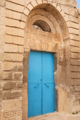 Bright blue door in an elaborate facade of a traditional house in the old town of Mardin, Turkey