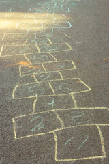 Chalk drawings on asphalt. Hopscotch game concept. Childhood concept. Painted numbers on the road. Outdoor games. Children activity. Outdoor playground in the city. Colourful hopscotch line. - 795422798
