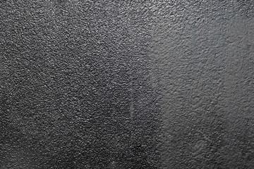 The surface of the wall is coated with black glossy paint, providing a sleek and shiny finish.