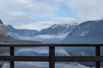 Paisaje del lago Hallstat y las montañas nevadas al fondo en un mirador con valla de madera