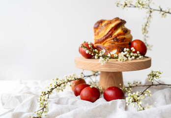 Festive table setting, Easter pastries on a wooden stand and cherry blossoms. Easter holiday concept.