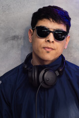 Obraz premium Dj posa con auriculares y gafas de sol