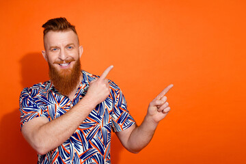 Photo of excited funky guy dressed print shirt showing two fingers emtpy space isolated orange...