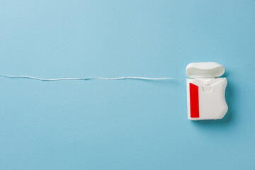 Top view of dental floss in white box on blue background