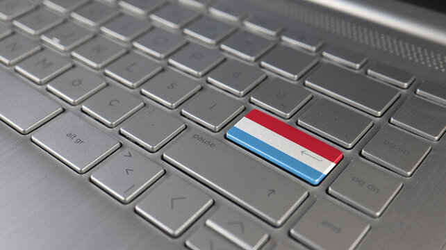 Keyboard with Luxembourg flag on the enter button, represents cyber attack, learning language