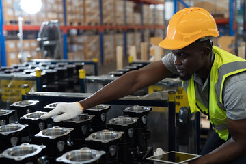 African American male warehouse worker wear safety uniform, helmet and inspecting quality of products in storage warehouse