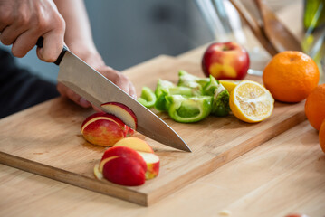 Hand chef knife cut and slice fresh Vegetables baby cos salad on wood board table .Make Salad...