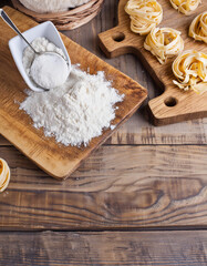  ingredienti per fare la pasta, farina, su un tagliere di legno