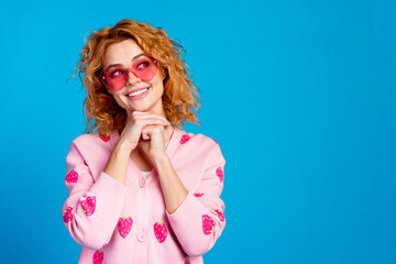 Photo portrait of attractive young woman sunglass dreamy look empty space dressed stylish pink clothes isolated on blue color background