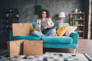 Photo of charming cheerful woman dressed stylish clothes sitting on soft sofa indoors