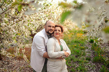 happy couple of adults on a walk in the spring park. family leisure. husband and wife walking in nature