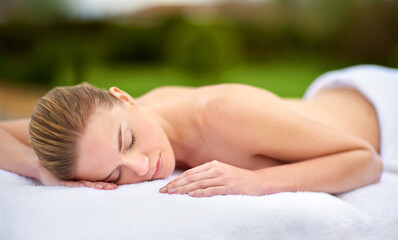 Spa, relax and massage with woman on bed for healing, treatment or pamper in peace at luxury hotel....