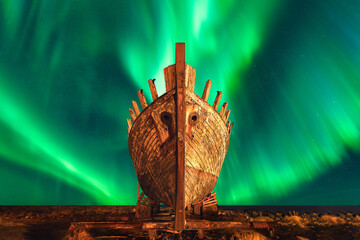 Green Lady (Aurora Borealis) across the sky above an old abandoned fishing ship stands silent under...